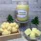 Yellow Honeysuckle and Jasmine soy candle, on gray pedestal, cube wax melt in glass bowl, and paw print wax melts in a rustic box, with 2 small tree plants for decoration.