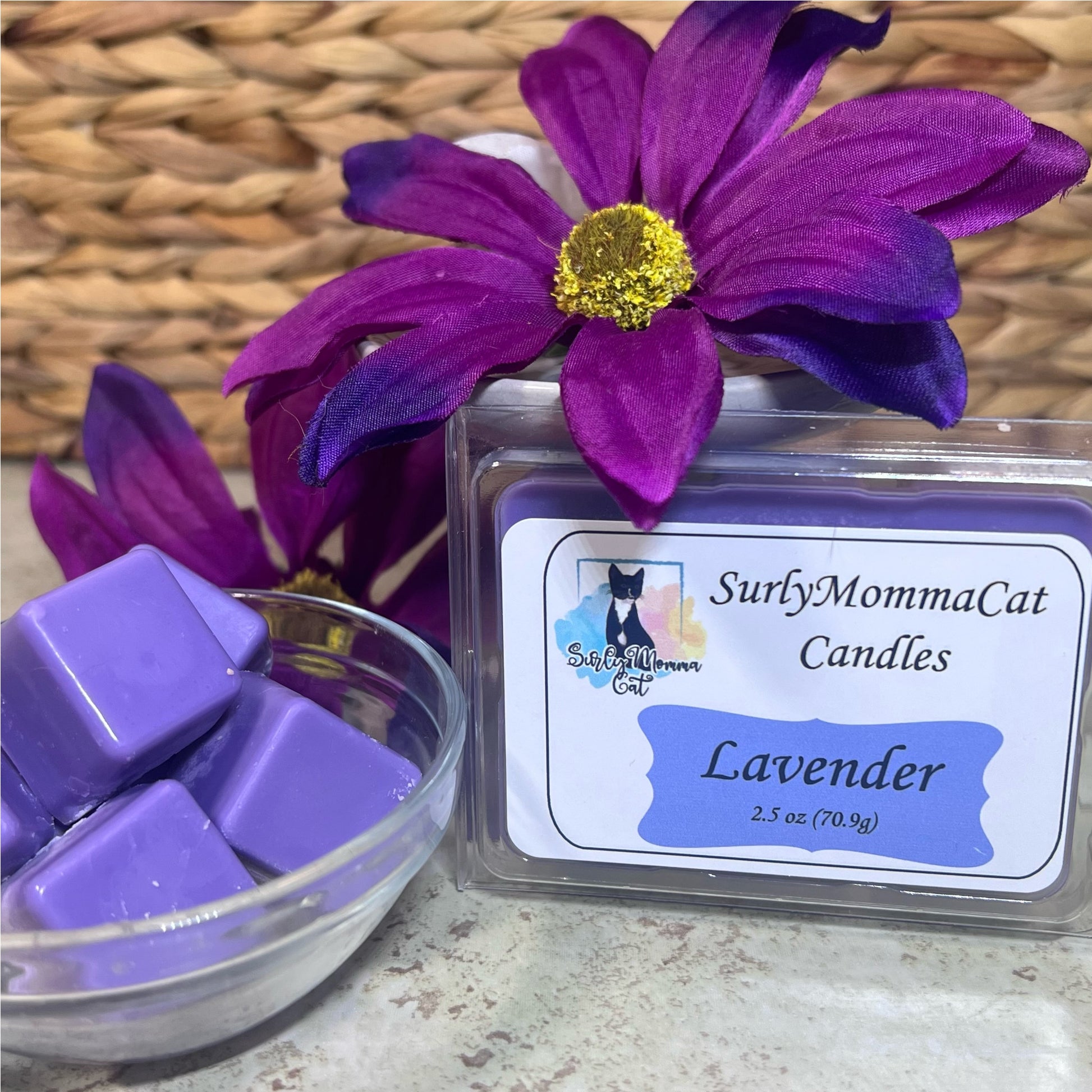 Purple Lavender Soy Cubed wax melts in a glass bowl, with a sealed Lavender wax melt , with two large purple flowers for decoration.