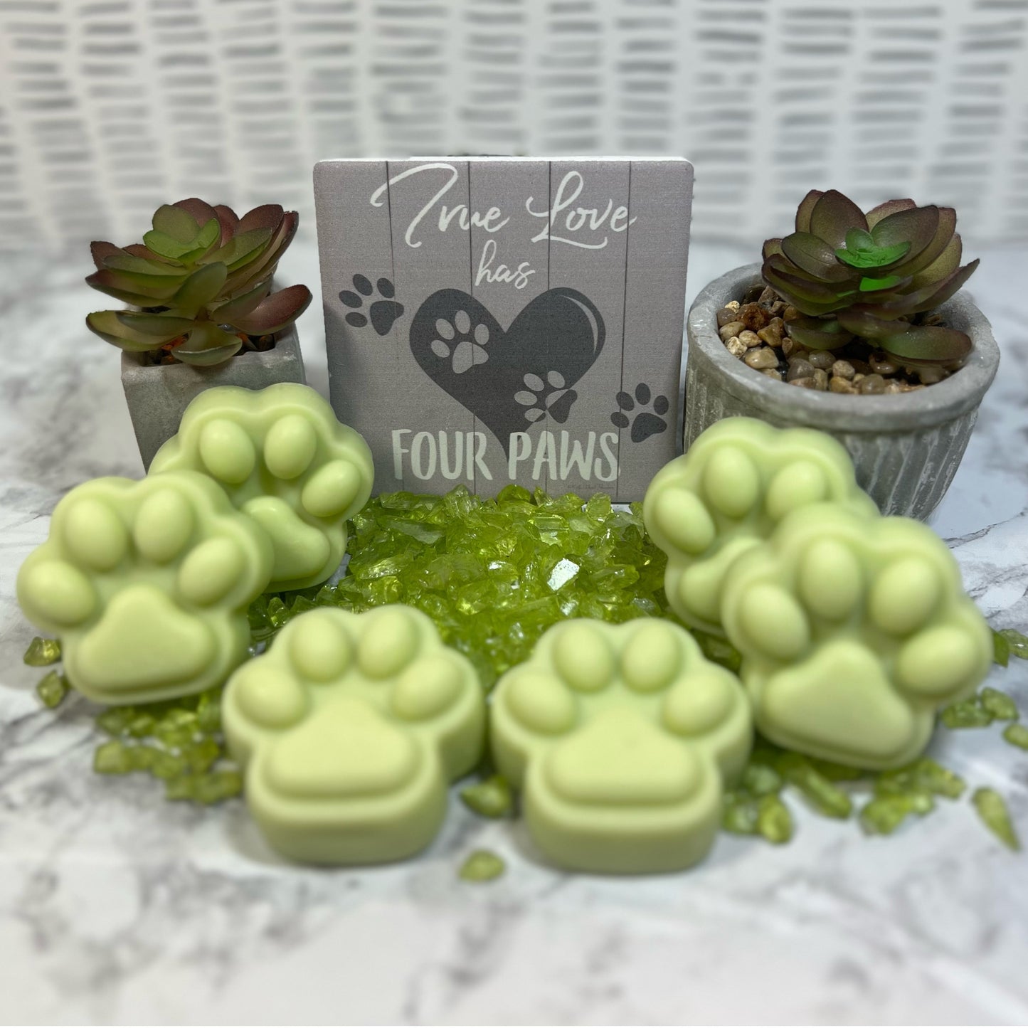 Light green soy Mint Mojito pawprint wax melts, with small plants, green glass beads, and a wooden sign "True love has four Paws" for decor.